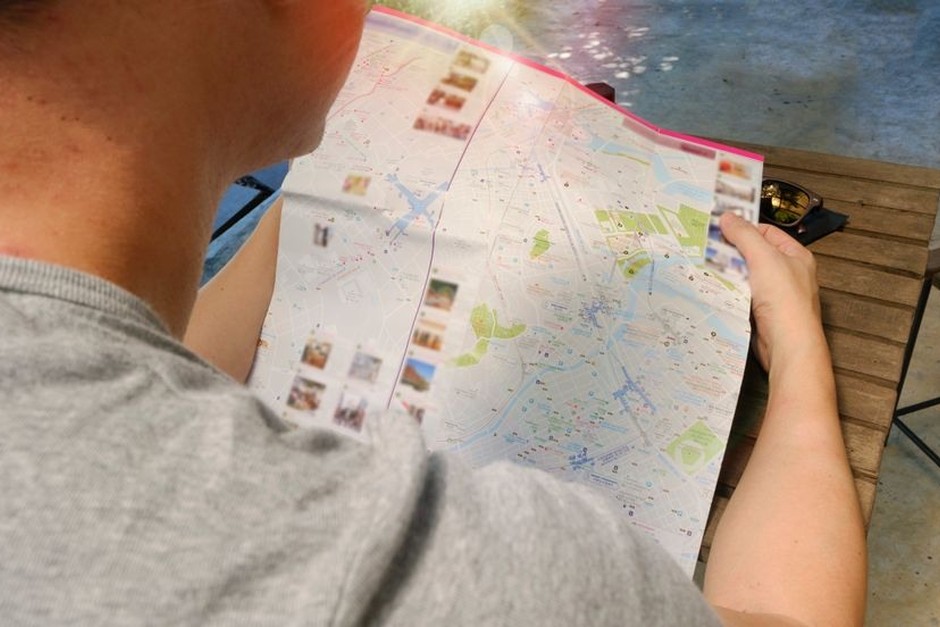 A traveller holding a city map while walking